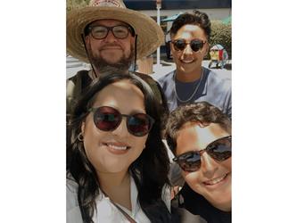 A man, woman, and two young boys smiling for a selfie