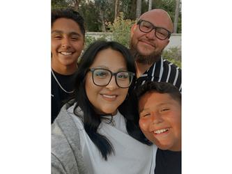 A man, woman, and two young boys smiling for a selfie